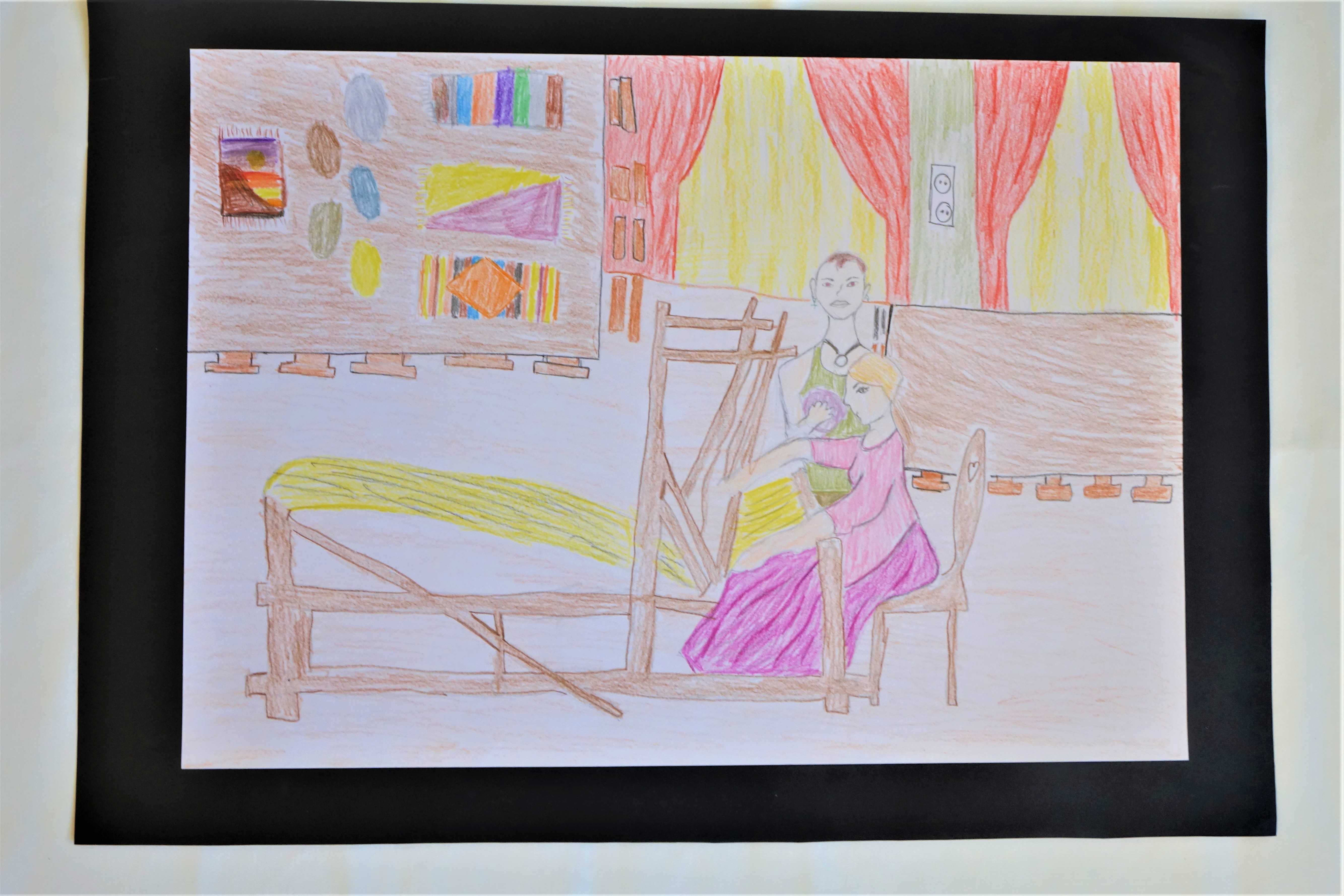 Ceruzával készült rajz, mely az intézmény szövödéjét örökíti meg. A kép előterében egy szövőszék látható, mellette egy női alak ciklámen ruhában. A női alak mellett egy férfialak áll, gombolyaggal a kezében. A kép hátterében két asztal látható székekkel. A bal oldali asztalon fonalgombolyagok és kész szőnyegek, a jobb oldali asztal üres. Látható a háttérben két ablak, piros függönnyel.
