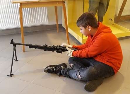 Kisfiú egy fegyvert tanulmányoz