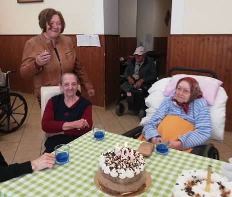 A képen az ünnepelt látható tortával és a köszöntőkkel